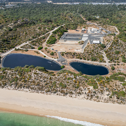 Aerial view of a wastewater treatment plant and surrounding landscape. 