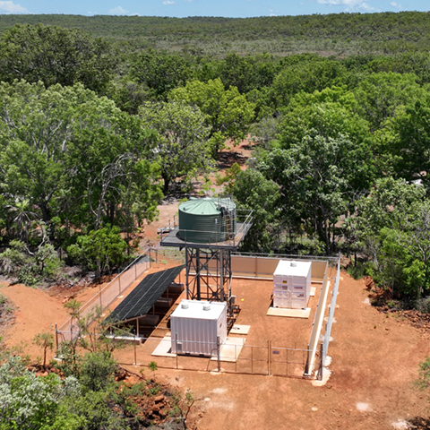 Chlorinator units and solar panels next to an elevated tank in the remote outback of Western Australia.