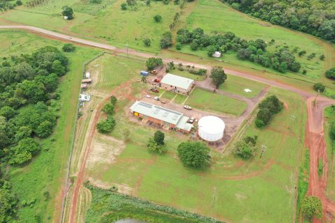 Aerial view of the Bamaga water treatment plant and ponds. The buildings have light roofs and are surrounded by grass, dirt roads and patches of trees.