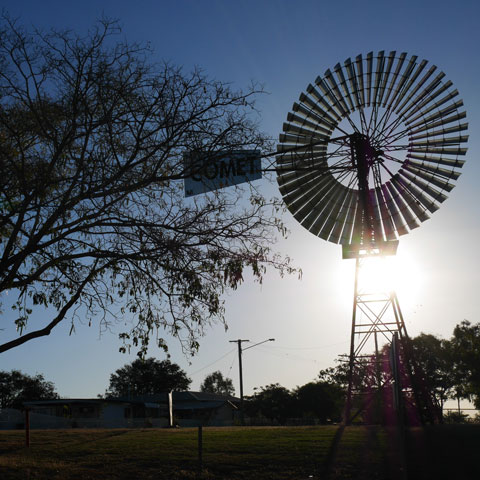 Silhouetted tree and Windmill at sunset near Hughenden Queensland