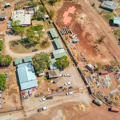 Aerial view of the community of Kalkaringi, Northern Territory, showing housing and parked cars in a desert area.