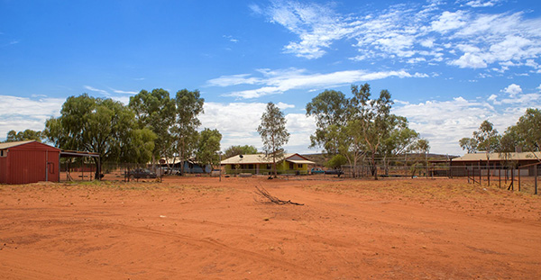 Australian desert and corrugated iron buildings in the background.