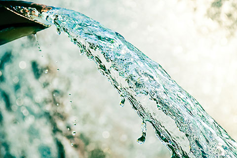 Close up of water gushing out of the pipe